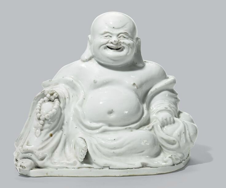 A Chinese white-glazed figure of Budai, Qing dynasty, 18th century