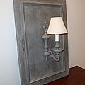 Applique montée sur une ancienne porte en bois, le tout patiné taupe et cérusé