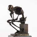Sculpture en bronze à patine noire représentant un squelette dans une attitude de penseur. Travail moderne