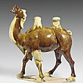 A massive well-modeled chestnut and cream-glazed pottery figure of a Bactrian camel, Tang dynasty (618-907)